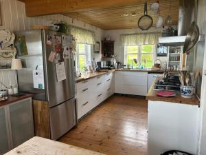 a kitchen with a stainless steel refrigerator and white cabinets at House at the farm! in Tromsø
