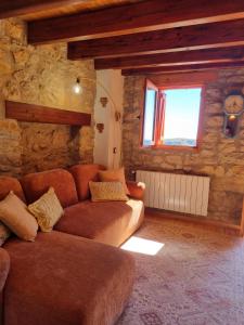 a living room with a couch and a stone wall at Casa Rural Haiku in Bojar