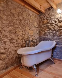 a bath tub in a room with a stone wall at Casa Rural Haiku in Bojar +25 photos