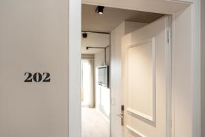 a door leading to a hallway with a television at Giessen Hotel & Coffeehouse in Vaduz