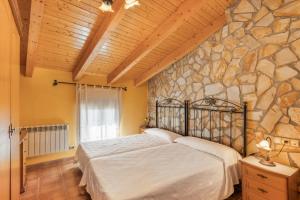 a bedroom with a bed and a stone wall at Casa Maluenda in Maluenda