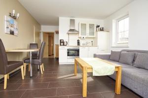ein Wohnzimmer mit Sofa und Tisch in der Unterkunft Schicke FeWo mit Terrasse, gratis Nutzung vom AHOI Erlebnisbad und Sauna in Sellin - Haus De niege Wech FeWo 01 in Thiessow
