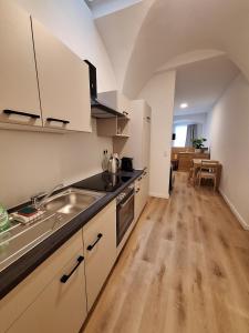 a kitchen with white cabinets and a wooden floor at Apartment im Stadtzentrum in Steyr