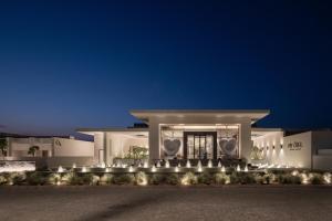 a large white building with lights in front of it at My Ōtel North Coast - Adult Only in Al Dabaa