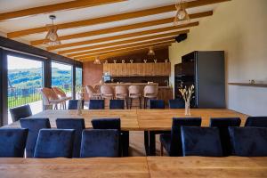 a dining room with a large wooden table and chairs at Apuseni Peak Paradise in Sălciua de Sus