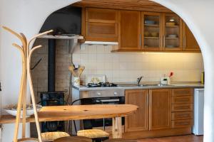 a kitchen with wooden cabinets and a wooden table at Charming Studio apartment in Sintra, Penedo in Colares