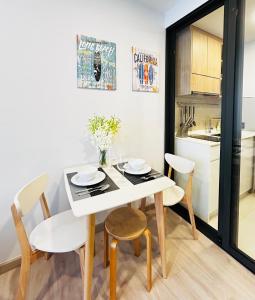 une cuisine et une salle à manger avec une table et des chaises blanches dans l'établissement 1 Bdr Sky Park Golf view, à Bang Tao Beach 14 autres photos