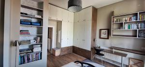 a living room with a desk and bookshelves at apartament na 5 in Tarnów