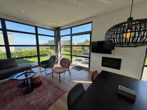 a living room with a couch and a table and chairs at Enkhuizer Strand Chalet IJsselmeerblick Zweite Reihe mit Zaun Haus Nr 221 in Enkhuizen
