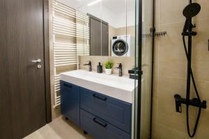 een badkamer met wastafel en douche met spiegel bij Smart Stay Plaza in Boekarest +64 foto's