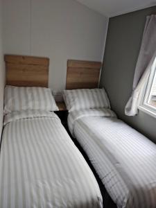 Un pat sau paturi într-o cameră la New Caravan at Trecco Bay Holiday Park