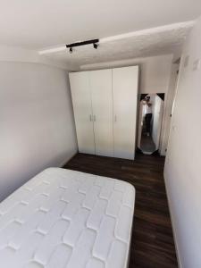 Un dormitorio con una cama blanca en una habitación. en Calma, en Alicante