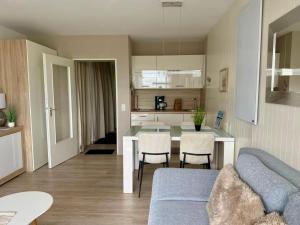 ein Wohnzimmer mit einer blauen Couch und eine Küche in der Unterkunft Nautic 108 in Cuxhaven