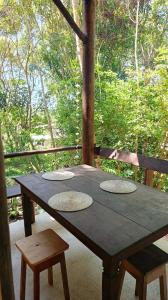a wooden table sitting on a porch with two chairs at House in the Trees in Ilha de Boipeba