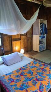 a bedroom with a bed with a mosquito net at House in the Trees in Ilha de Boipeba
