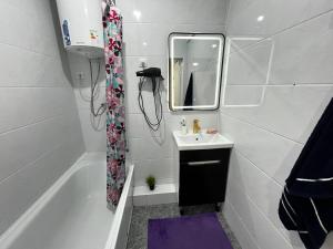 une salle de bain avec une baignoire, un lavabo et un miroir dans l'établissement Muras apartment on Kalik Akieva 155, à Bishkek