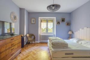 a bedroom with a bed and a dresser and a tv at Le Cocoon CléJa - Proche Station La Bresse in Ventron