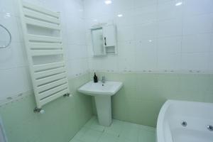a white bathroom with a sink and a toilet at Best Atmosphere Hostel in Baku