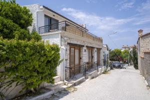 un edificio bianco con un balcone su una strada di Naro Suites Alaçatı Köyiçi a Çeşme