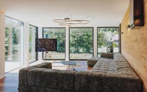 un soggiorno con un grande divano e ampie finestre di Exklusive King Suite mit Game Table in Hinterzarten a Hinterzarten