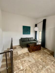 a living room with a green couch and a table at Beautiful Village Silk House, with terrace in Collias