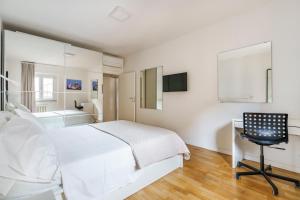 a white bedroom with a bed and a desk and a chair at CDT Duomo in Florence