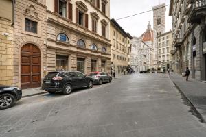 a city street with cars parked on the street at CDT Duomo in Florence