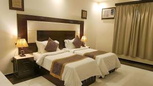 two beds in a hotel room with two lamps at جراند خيال للشقق المخدومة in Abha