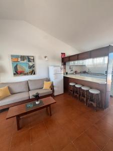Una sala de estar con un sofá y una cocina. en Los Porches k29, en Playa del Inglés