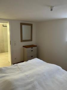 a bedroom with a white bed and a mirror at Rufus' Bergblick in Bernau am Chiemsee