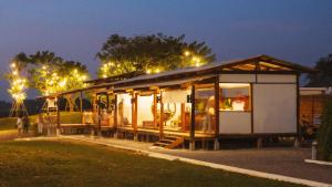 a small house with a lot of windows at night at West Mount Cafe & Restaurant in Ban Hua Hin