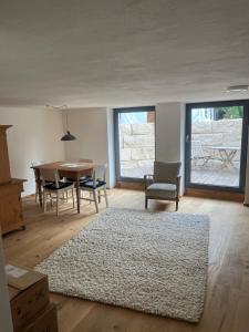 a living room with a table and chairs and a rug at Rufus' Bergblick in Bernau am Chiemsee