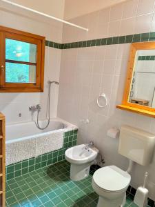 a bathroom with a toilet and a tub and a sink at Crans-Montana 3BR - Mountain View, Balcony and Parking in Crans-Montana