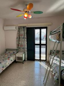 Un dormitorio con dos literas y un ventilador de techo. en Two Floor Maisonette by the Sea, en Protaras