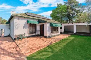 a house with a patio and a lawn at Private Garden Cottage with Kitchenette in Johannesburg