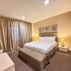 Spacious 4-Suite Villa with Balcony, Magic Village في أورلاندو: غرفة نوم بسرير ابيض كبير وستائر