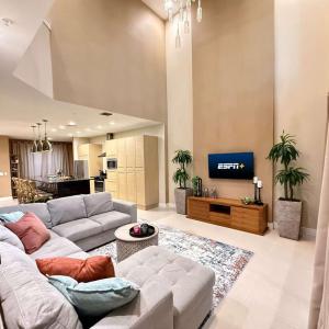 Spacious 4-Suite Villa with Balcony, Magic Village في أورلاندو: غرفة معيشة مع أريكة وتلفزيون