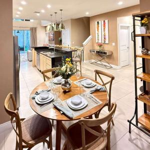 Spacious 4-Suite Villa with Balcony, Magic Village في أورلاندو: مطبخ وغرفة طعام مع طاولة وكراسي خشبية