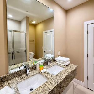 Spacious 4-Suite Villa with Balcony, Magic Village في أورلاندو: حمام مع حوض ومرآة كبيرة