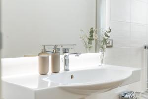 a bathroom sink with two soap dispensers on it at Vico21 nel centro di Modica in Modica +13 photos