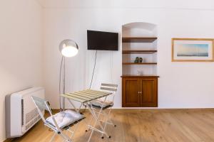 a room with a table and chairs and a television at Vico21 nel centro di Modica in Modica
