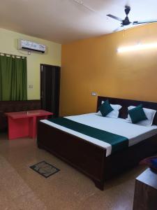 a bedroom with a large bed and a red table at VIP Residency Hotel And Restaurant in Shānti Niketan