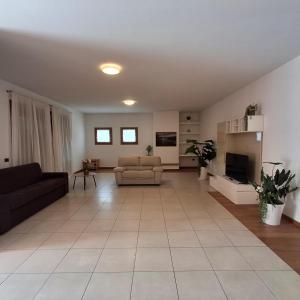 卡斯特努沃德加尔达Villa Montalto Castelnuovo del Garda的客厅里有一张沙发和一台电视