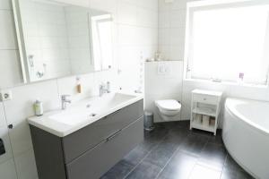 Un baño blanco con lavabo e inodoro. en NEU! Ferienhaus Mein Geestland, en Imsum 15 fotos más