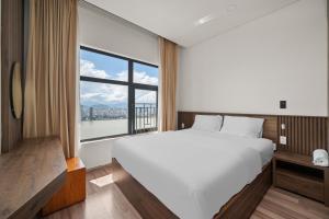 a bedroom with a large bed and a large window at Monarchy Riverside Da Nang - Modern Stay & Pool in Da Nang +30 photos