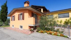 una casa gialla con dei fiori davanti di Appartamento Ai Prati a Lazise