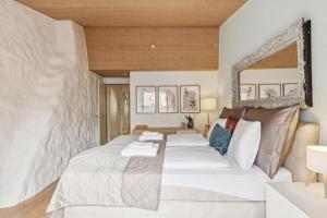 a bedroom with a large white bed and a mirror at Aaacentralriversidepenthousewbalcony&waterview in Zürich