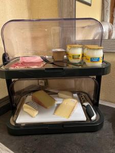 ein Behälter mit Käse und anderen Gegenständen auf einem Tisch in der Unterkunft Chambre d'hôtes l'Olivianne in Sarlat-la-Canéda + 14 Fotos