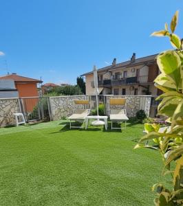 卡斯特努沃德加尔达Villa Montalto Castelnuovo del Garda的有绿草、椅子和建筑物的后院 更多3张照片