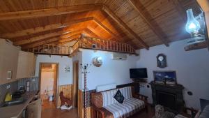 a living room with a couch and a wooden ceiling at Bujtina Anesi in Poliçan